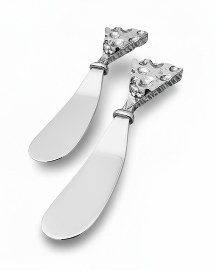 Two decorative hammered silver butter cheese knives with intricate designs on a white background