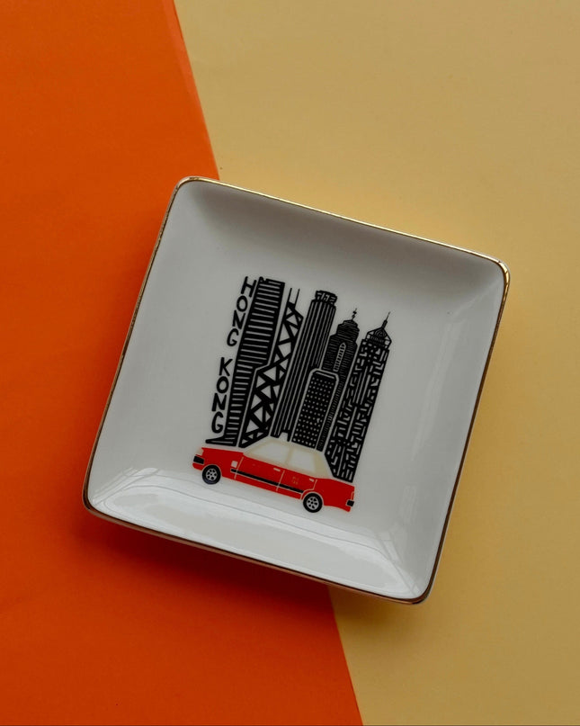 Square ceramic dish with Hong Kong cityscape design and Iconic Red Taxi on an orange and beige background