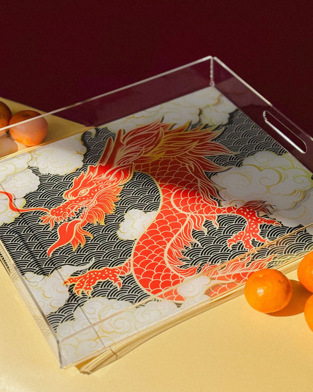 Tray with a dragon design and mandarin oranges on a yellow surface
