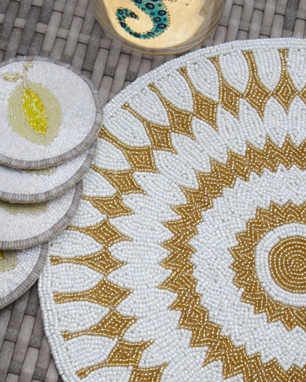 Set of decorative coasters and placemat with intricate patterns on a woven surface