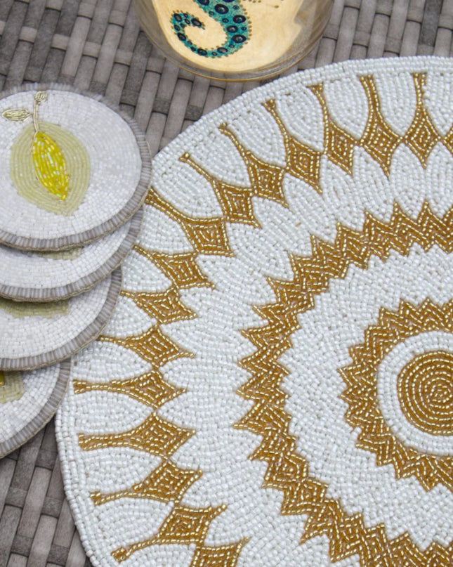 Set of decorative coasters and placemat with intricate patterns on a woven surface