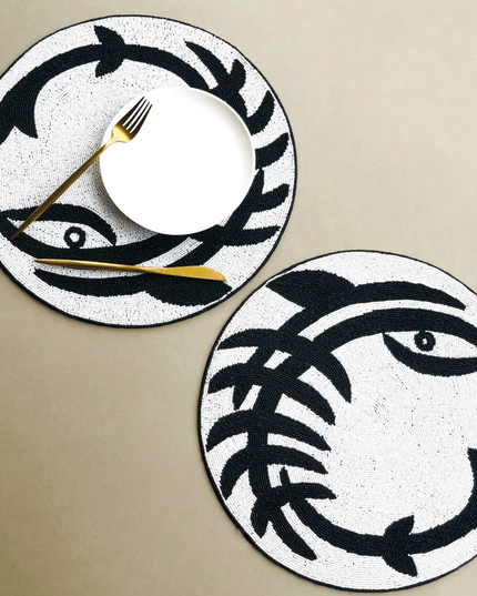 Two Beaded Black White Round Abstract Placemats with white plate and gold Fork and Knife