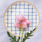 Casa Duniya's White Blue Checkered Bone China Zambila Dessert Plate with Pink Flower against White Linen Background