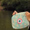 Hand Holding an Turquoise Cosmetic Pouch with Pink Evil Eye Embroidery 