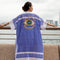 Asian Girl Wearing a Hand-Painted Evil Eye Blue and White Beach Cover Up with Hong Kong Sklyline in the Background