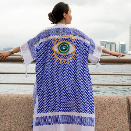 Casa Duniya's Hand-Painted Evil Eye Blue and White Beach Cover Up with Hong Kong Sklyline in the Background