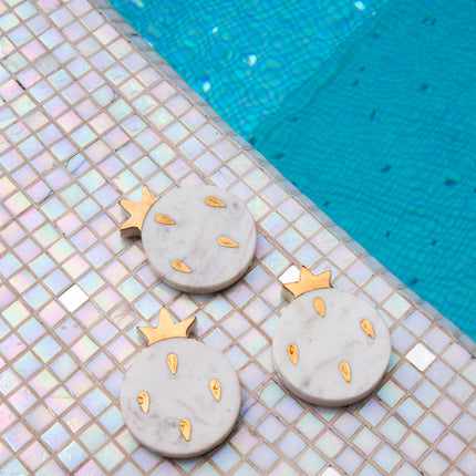 Casa Duniya's White Marble With Brass Inlay Pomegranate Granada Coasters at the Poolside