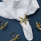 Casa Duniya's Gold and Turquoise Starfish Napkin Rings on a White Napkin and Blue Background