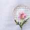 Casa Duniya's Blue and White Checkered Bone-China Zambila Dessert Plate with a Pink Flower and a White Linen Background