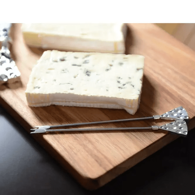 Set of 2 hammered silver Appetizer picks on a wooden cheese board.