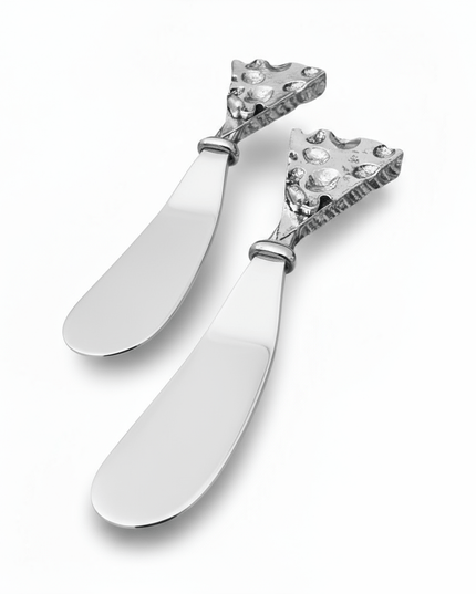 Two decorative hammered silver butter cheese knives with intricate designs on a white background