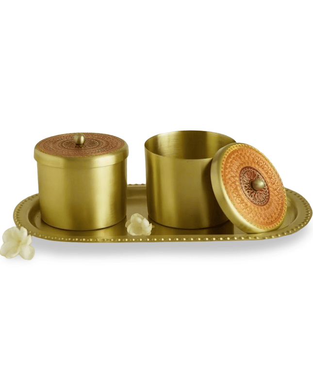 Set of gold brass containers with a decorative tray on a white background