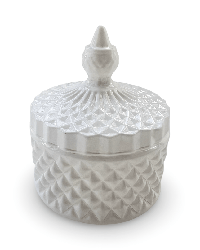 Decorative white glass jar with a prism-cut design and a small finial on a white background
