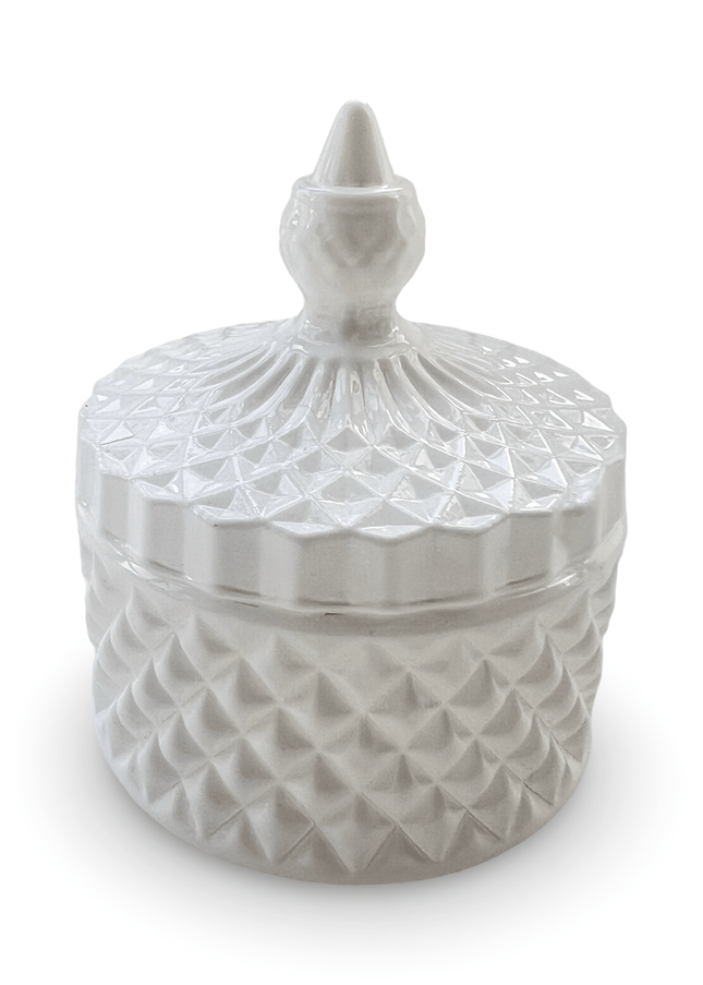Decorative white glass jar with a prism-cut design and a small finial on a white background