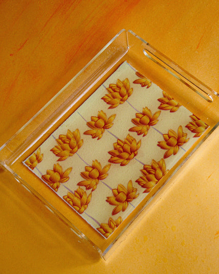 Clear acrylic tray with gold lotus design on a yellow surface
