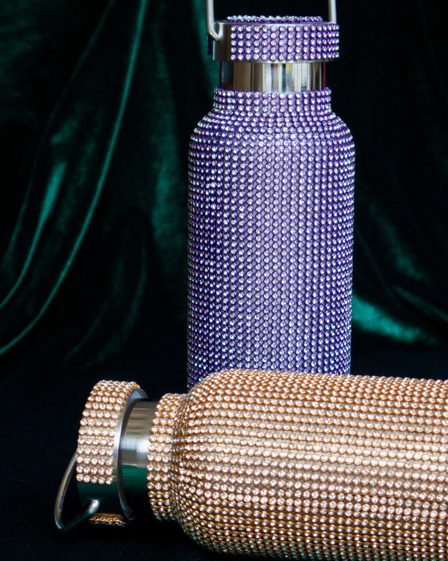 Purple and rose gold water bottles with rhinestone detailing on a dark background