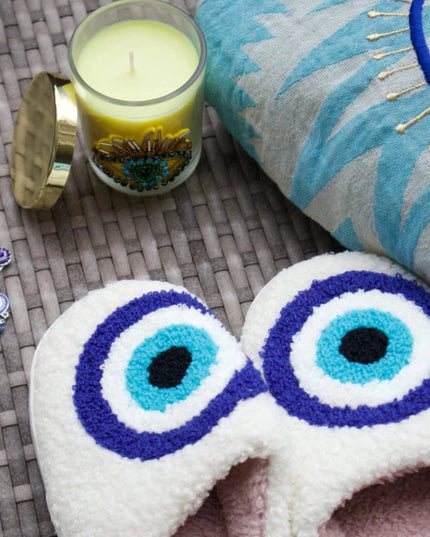 Evil Eye Embroidered Pouch, Evil Eye Slippers, Evil Eye Candle and Evil Eye Brooch on a Woven Mat