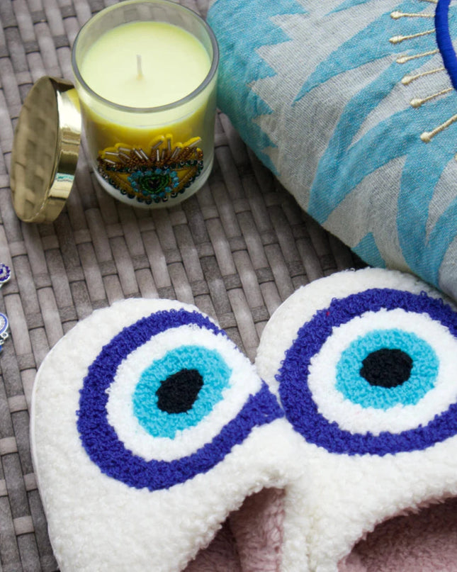 Evil Eye Embroidered Pouch, Evil Eye Slippers, Evil Eye Candle and Evil Eye Brooch on a Woven Mat