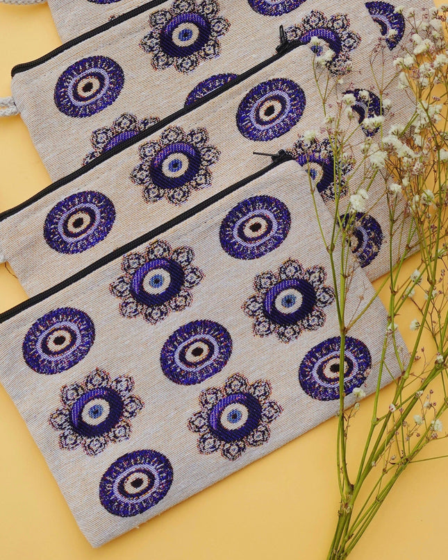 Set of four pouches with blue evil eye patterns on a yellow background