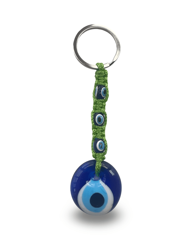Keychain with blue evil eye charm and green macrame on a white background