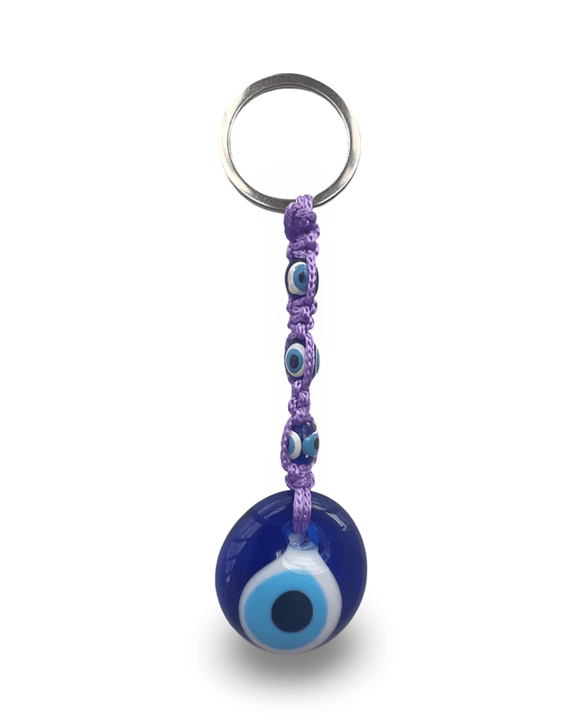 Keychain with blue evil eye charm and purple macrame on a white background