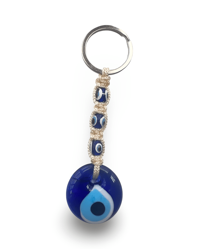 Blue evil eye keychain with off white macrame on a white background