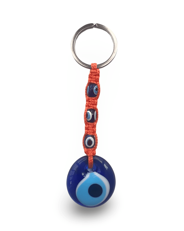 Keychain with blue evil eye charm and orange macrame on a white background