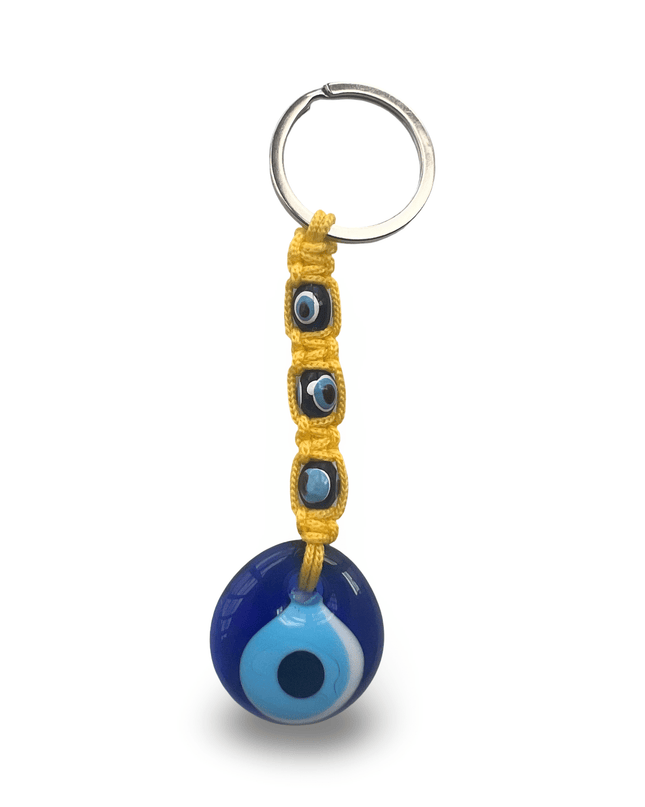 Keychain with blue evil eye charm and yellow macrame on a white background