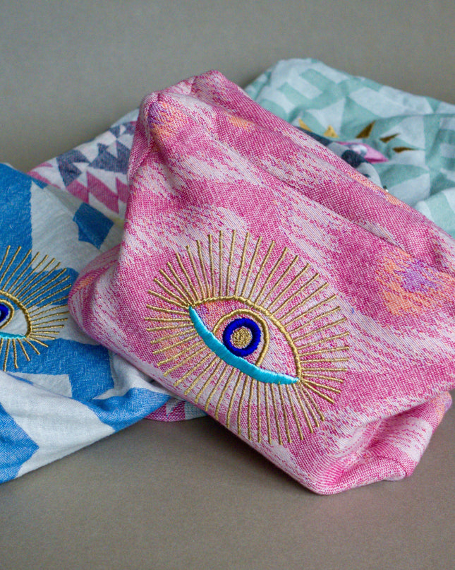 Embroidered Evil Eye Cosmetic Pouches on a Gray Background