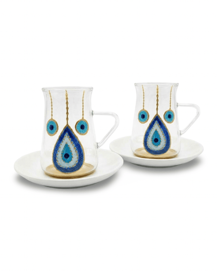 Clear glass tea cup with clear handle and hand-painted blue and gold evil eye on a round white porcelain saucer