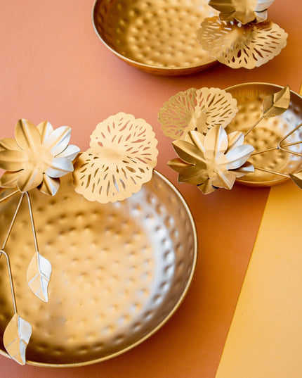 Gold decorative bowls with floral designs on a two-tone background