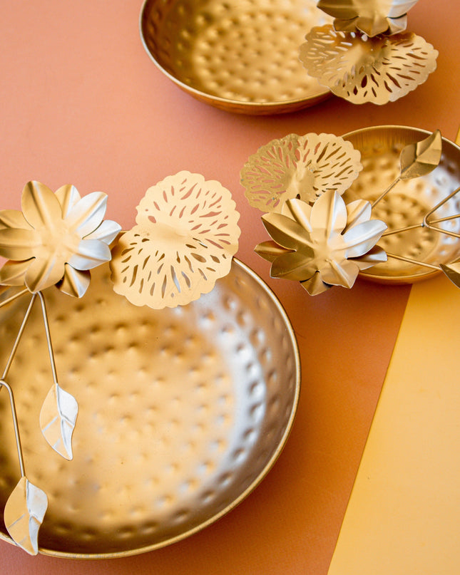 Gold decorative bowls with floral designs on a two-tone background