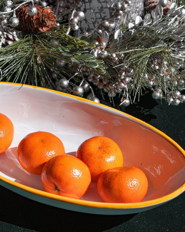 Oranges on a decorative plate with Christmas decorations in the background