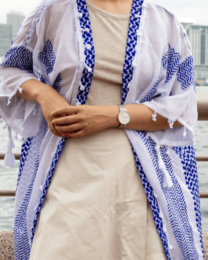 Person wearing a blue and white patterned kimono-style garment with a cityscape background.