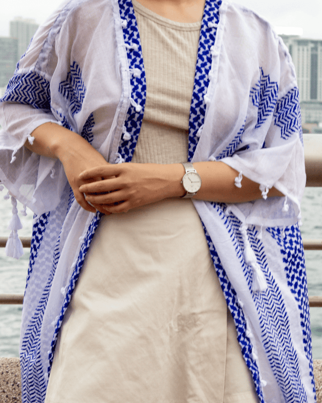 Person wearing a blue and white patterned kimono-style garment with a cityscape background.