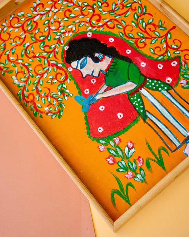 Decorative tray with a colorful artistic design of an Indian woman and floral elements on an orange background.