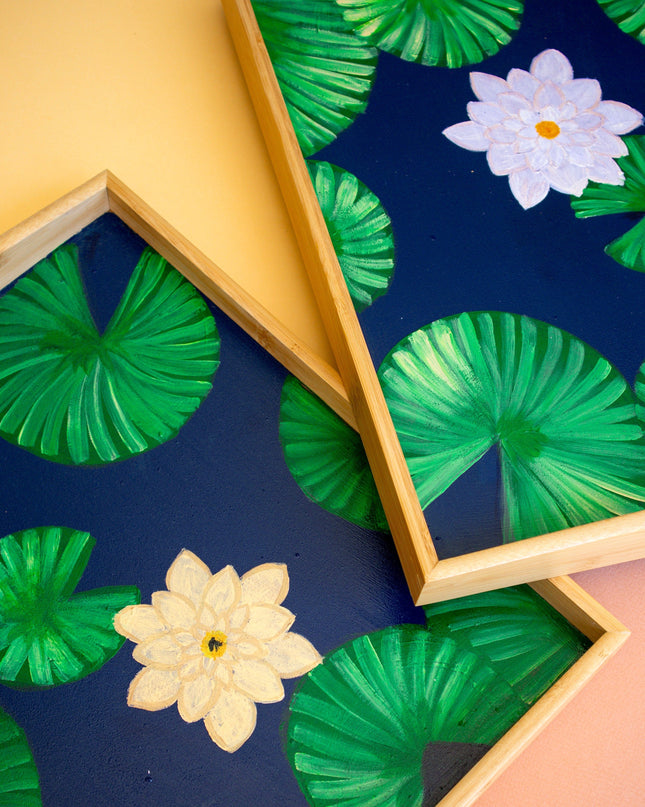 Wooden trays with green leaf and pink and yellow flower pattern on a blue background