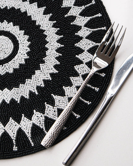 Black and white patterned placemat with a fork and knife on a white surface