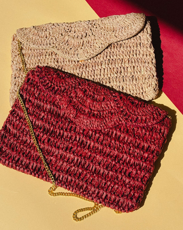 Two woven raffia handbags, one red and one beige, on a yellow and red background.