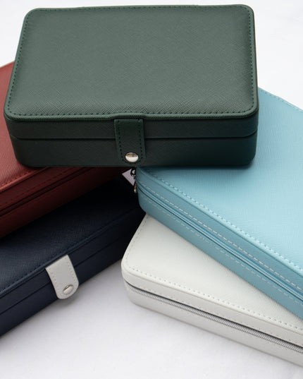 Stack of rectangular leather jewelry boxes in various colors on a white background