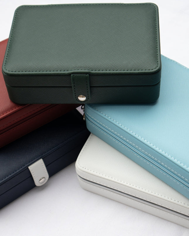 Stack of rectangular leather jewelry boxes in various colors on a white background