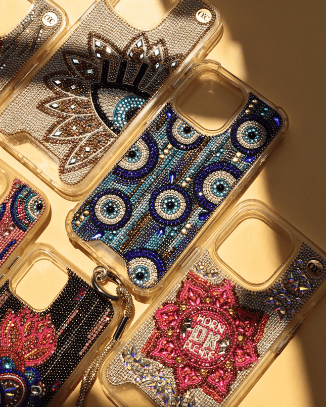 Decorative hand-beaded iphone cases with intricate designs and rhinestones on a beige background