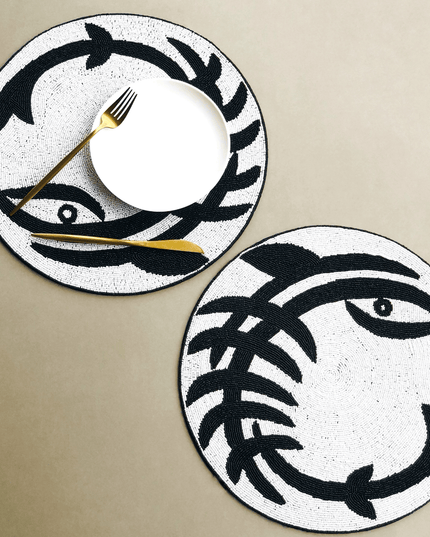 Two Beaded Black White Round Abstract Placemats with white plate and gold Fork and Knife