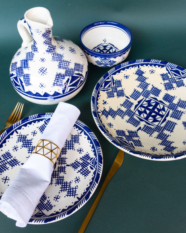 Set of blue and white patterned ceramic dishes on a green background