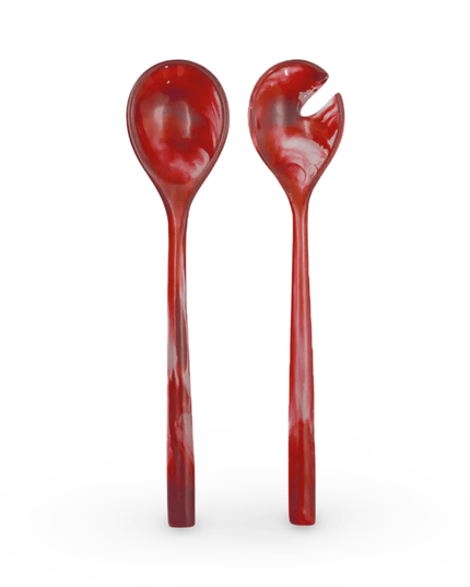 Two red resin salad servers on a white background