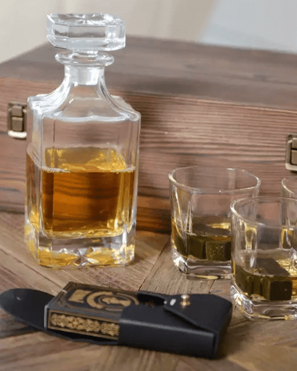 Whiskey decanter with glasses and a wooden box on a wooden surface