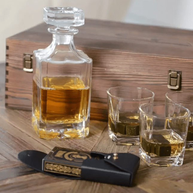 Whiskey decanter with glasses and a wooden box on a wooden surface