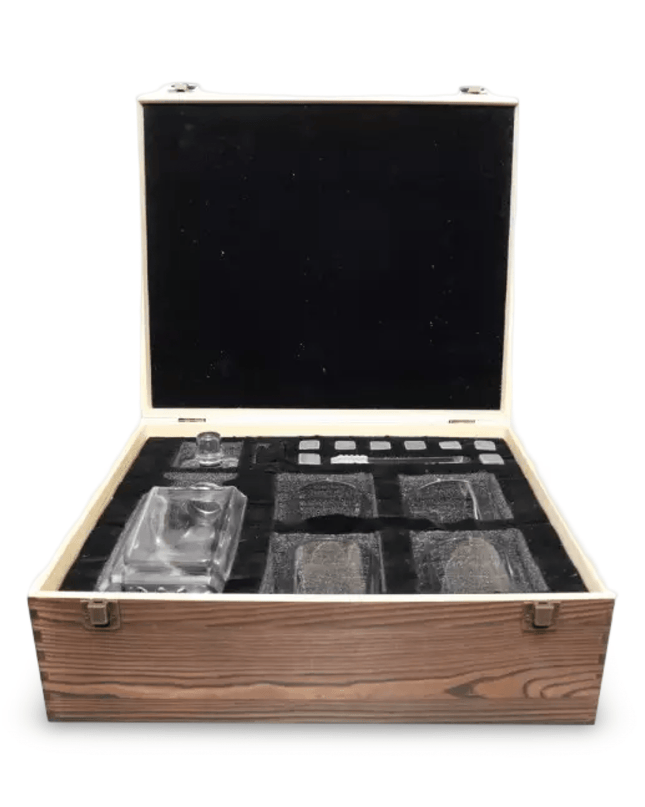 Set of glass tumblers and decanter in a wooden box on a white background