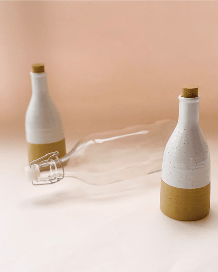 Two Beige Ceramic Bottles with Cork and a Glass Bottle