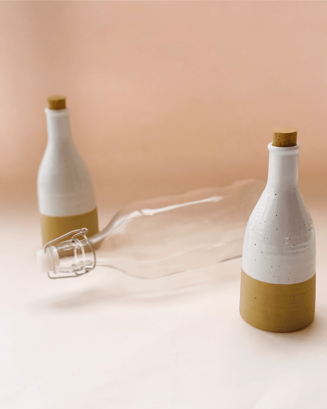 Two Beige Ceramic Bottles with Cork and a Glass Bottle